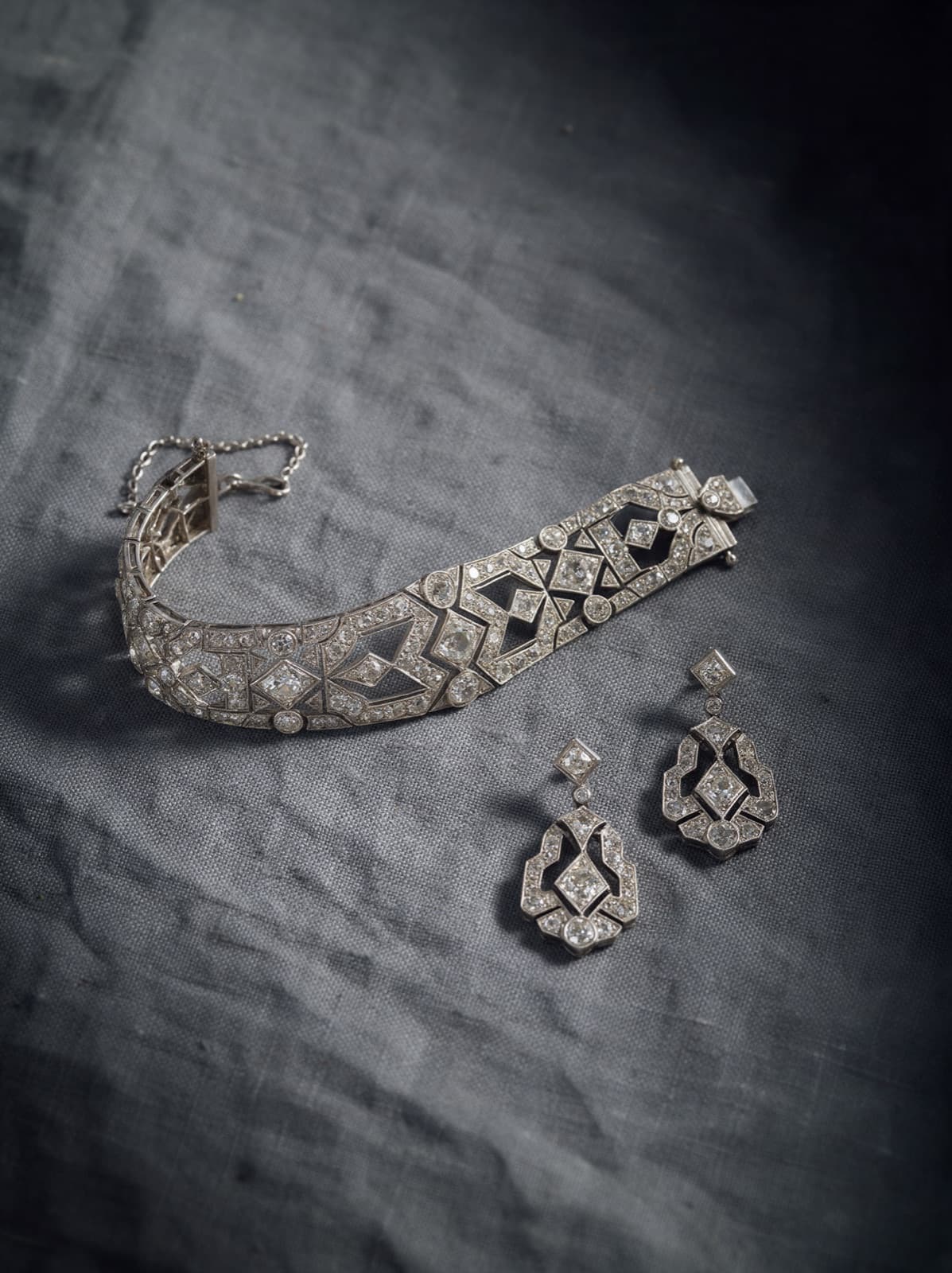 Signed high jewellery pieces including a diamond necklace and bracelet on dark velvet