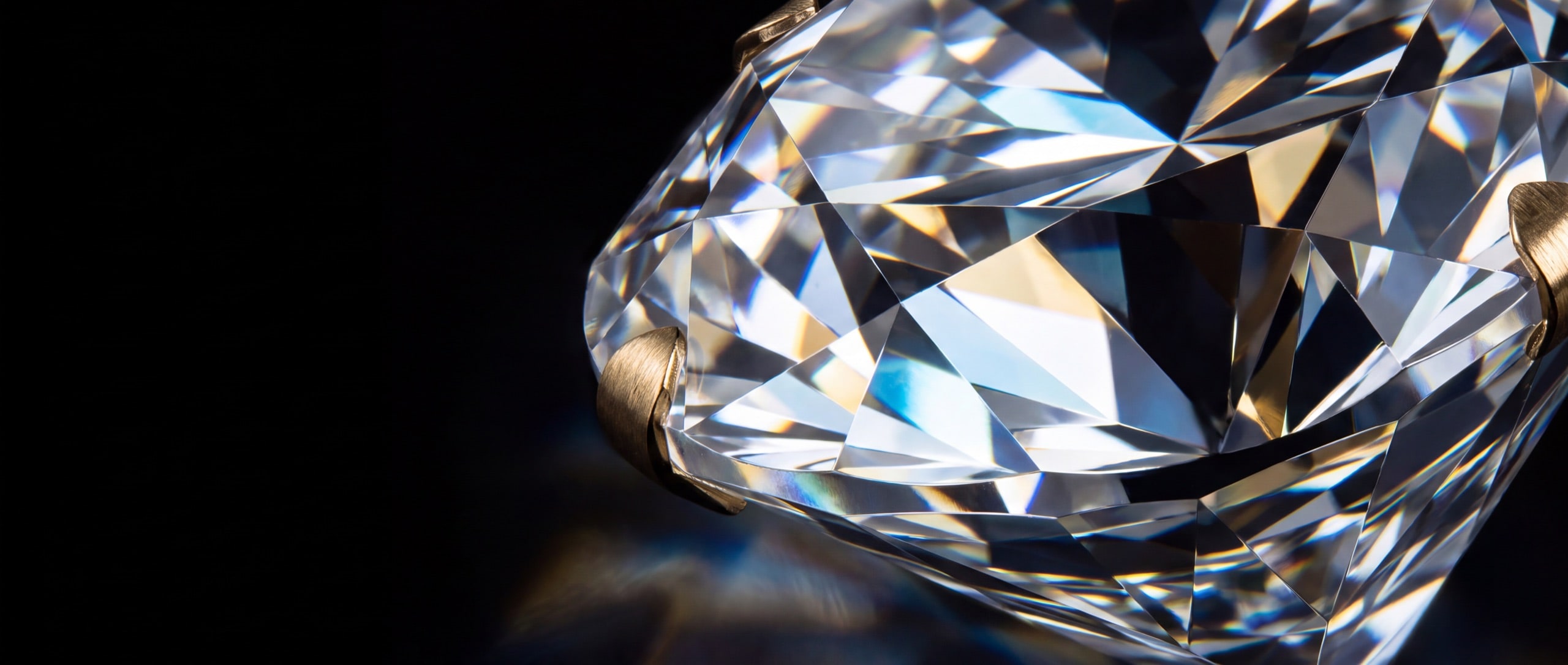 Extreme macro of diamond facet geometry refracting white, ice-blue and gold light